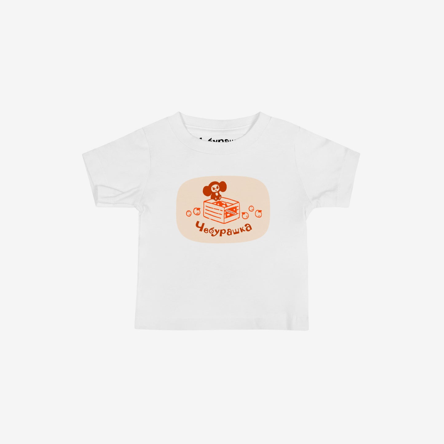 Unisex white baby Tee featuring Cheburashka sitting ona a box of oranges and Чебурашка logo in brown. High-quality 100% cotton.