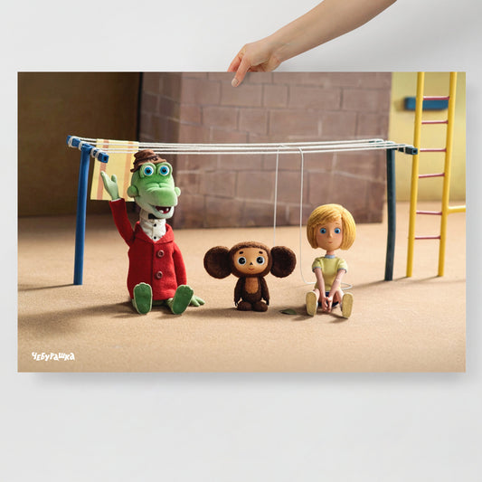 Hand holding large 91x61cm poster with Cheburashka and his friends Gena the crocodile and Galya on playground. Still frame from old original Soviet cartoon. With logo Чебурашка.