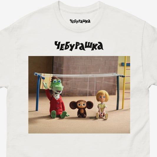 White unisex T-shirt with Cheburashka and his friends Gena the crocodile and Galya on playground. Still frame from old original Soviet cartoon. With logo Чебурашка. Closeup.