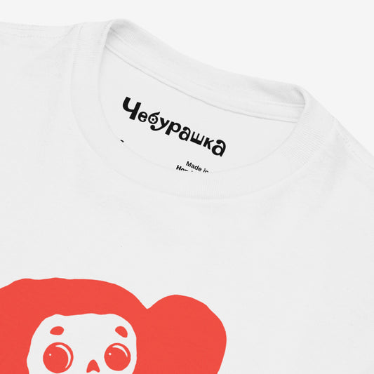 White unisex youth T-shirt with minimalist graphic of Cheburashka with flowers and チェブラーシカ japanese logo in red. Front closeup.