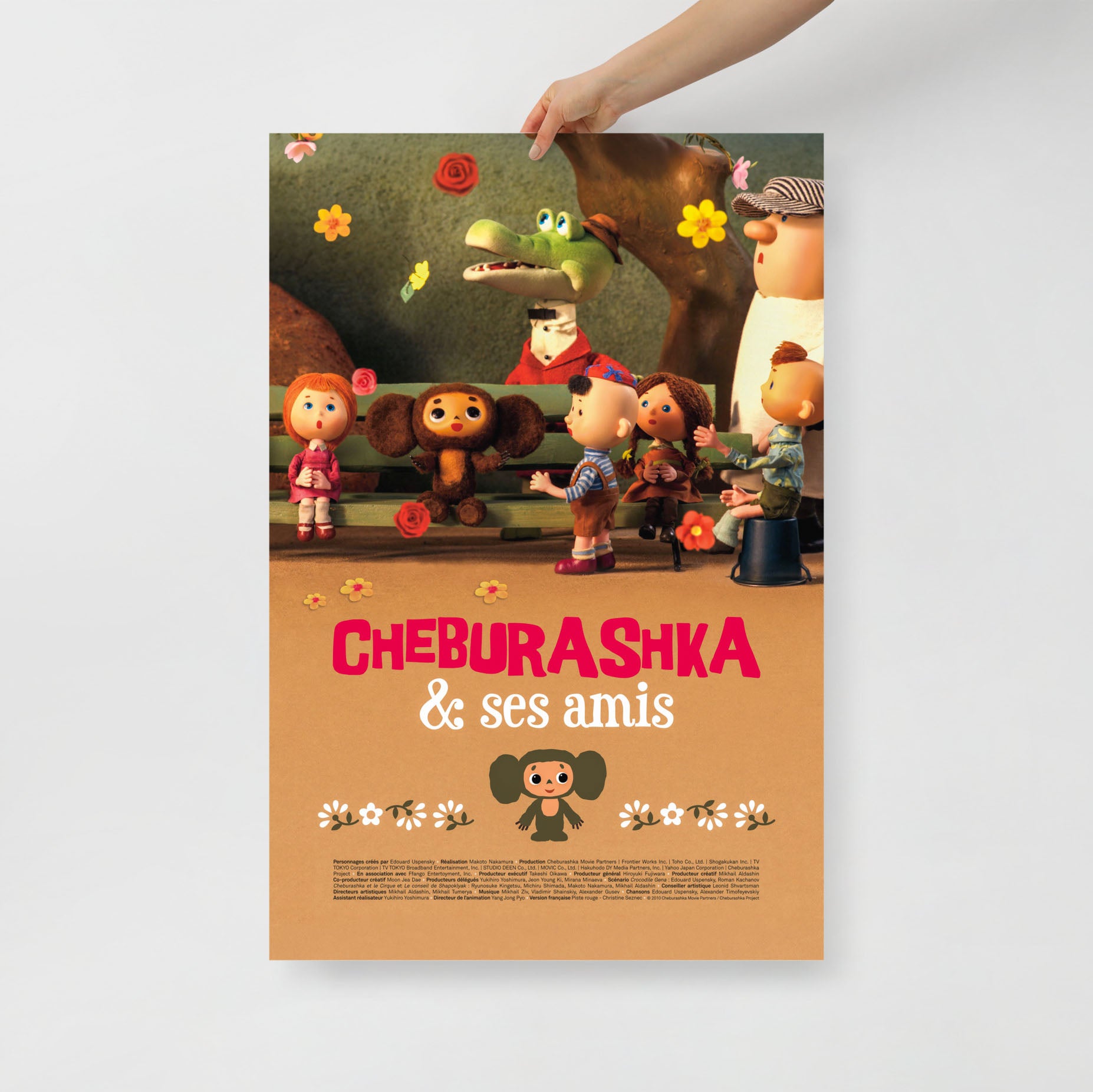 Hand holding Soviet cartoon 'Cheburashka And Ses Amis' french 2013 poster. 