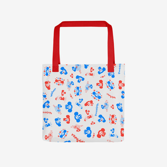 A white tote bag with a red shoulder strap, featuring an all-over pattern of red and blue original Soviet cartoon characters Cheburashka. Front photo.