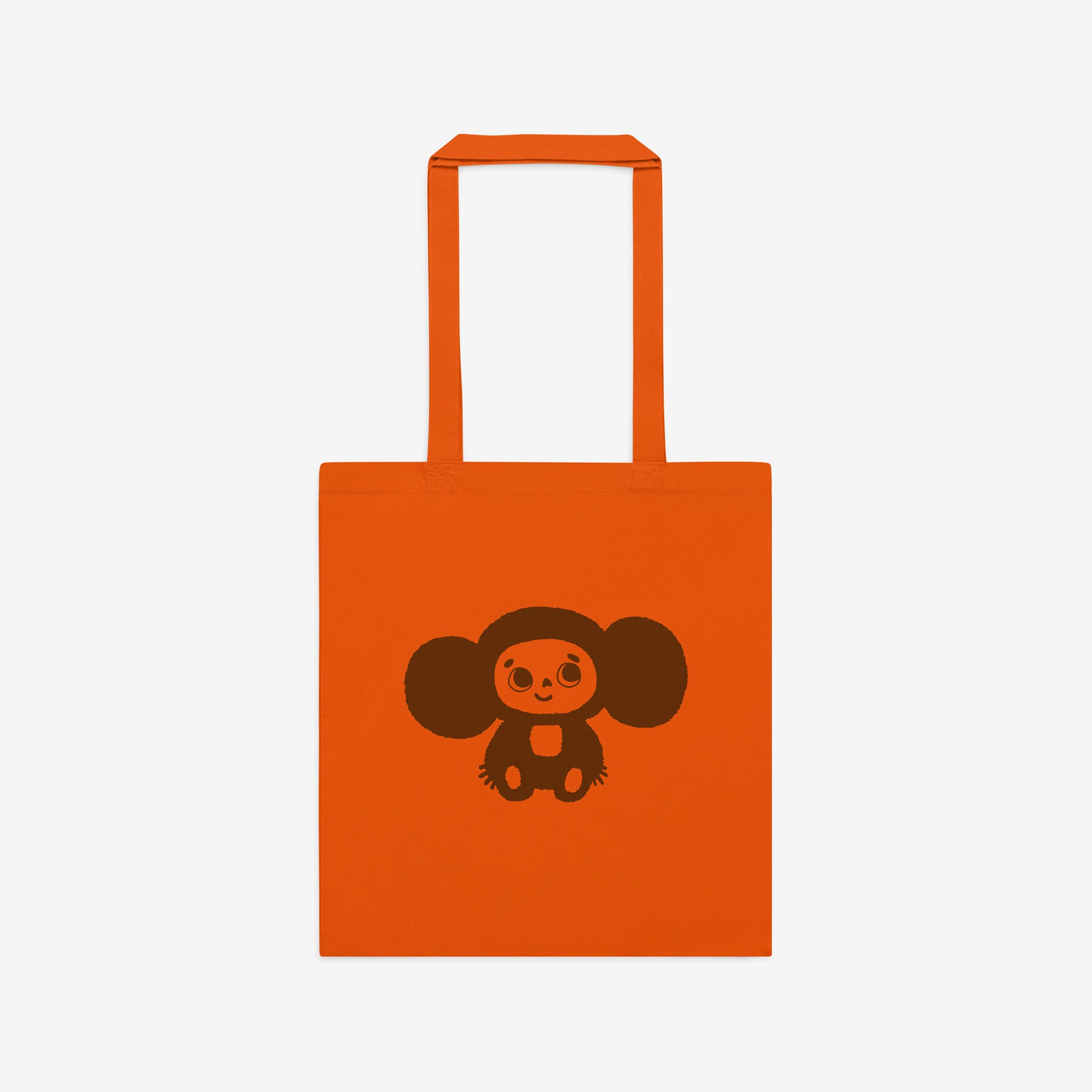 Orange tote bag with original Soviet cartoon character smiley minimalist Cheburashka on one side and Чебурашка logo on the other side. Front.