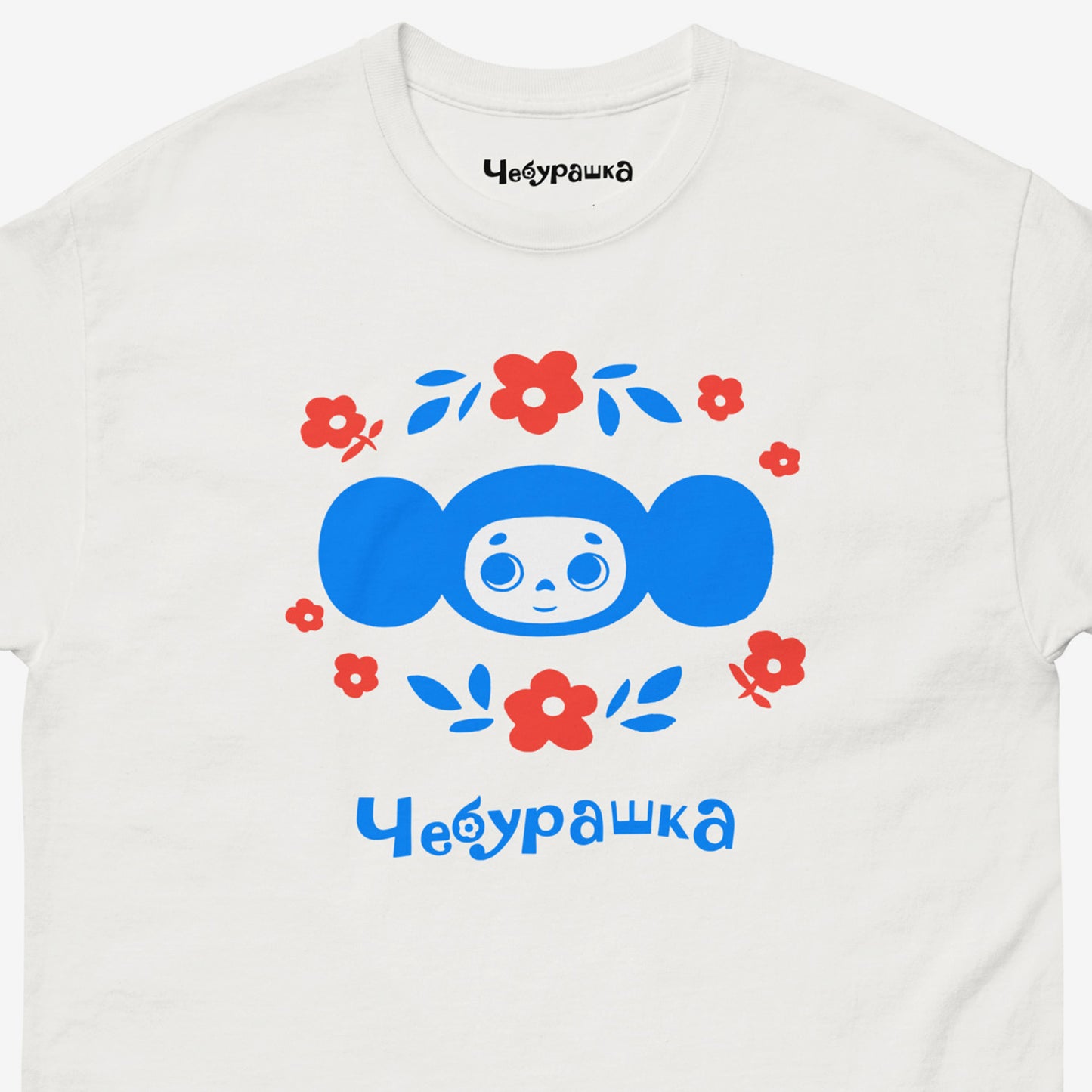 White unisex tee with original Soviet cartoon character Cheburashka. Cheburashka among flowers, in blue. Closeup print photo.