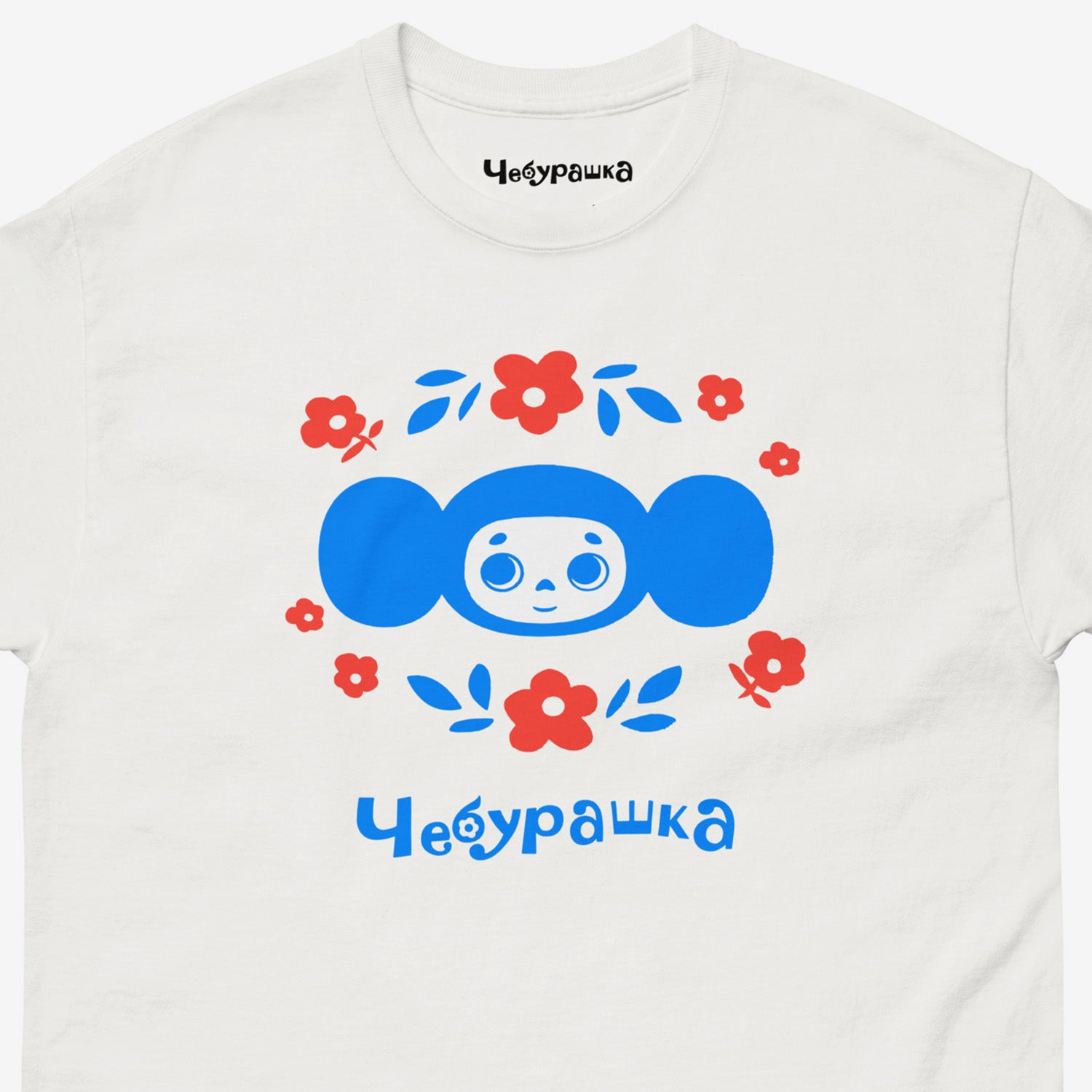 White unisex tee with original Soviet cartoon character Cheburashka. Cheburashka among flowers, in blue. Closeup print photo.
