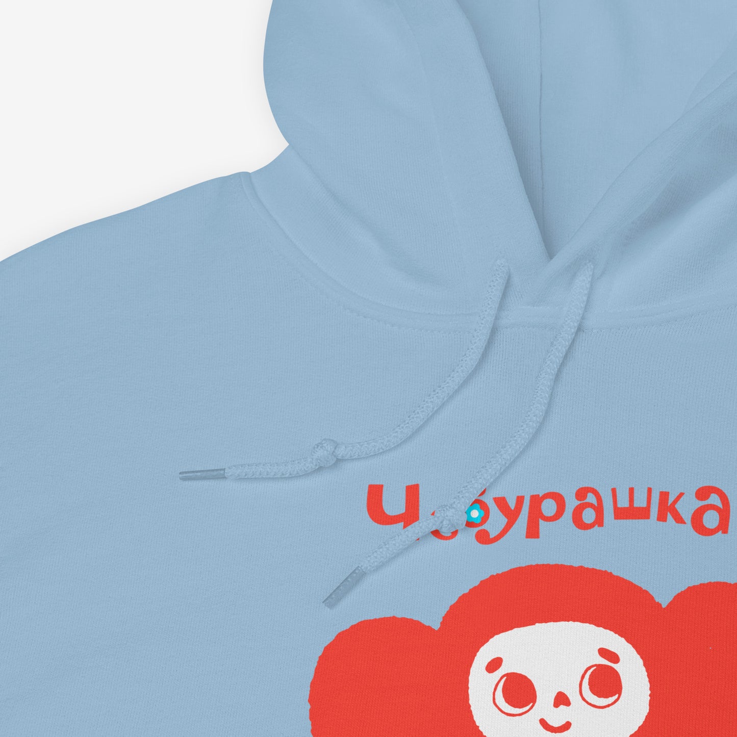 Light blue unisex hoodie featuring minimalist red Cheburashka with a birthday cake. Cute red-pinkish color. With Чебурашка logo on the necktag label. Closeup print photo. www.cheburashkashop.com