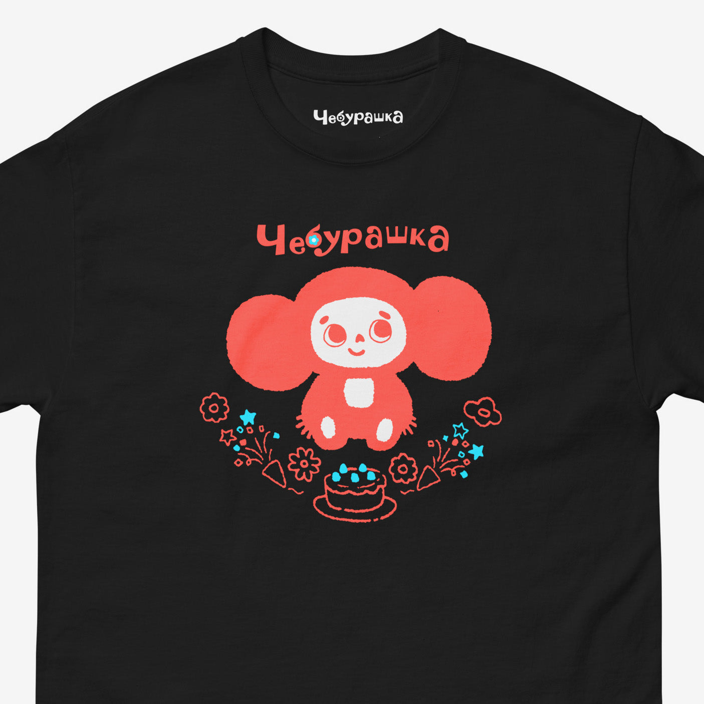Black unisex tee featuring minimalist red graphic of Cheburashka with a birthday cake. Cute red-pinkish color. Closeup photo with Чебурашка logo on necktag. www.cheburashkashop.com