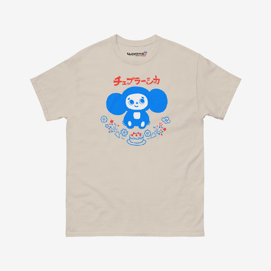 Beige unisex adult tee featuring minimalist Cheburashka with a birthday cake. Japanese edition with text チェブラーシカ. Cute baby-blue print color. With branded necktag logo Чебурашка. www.cheburashkashop.com