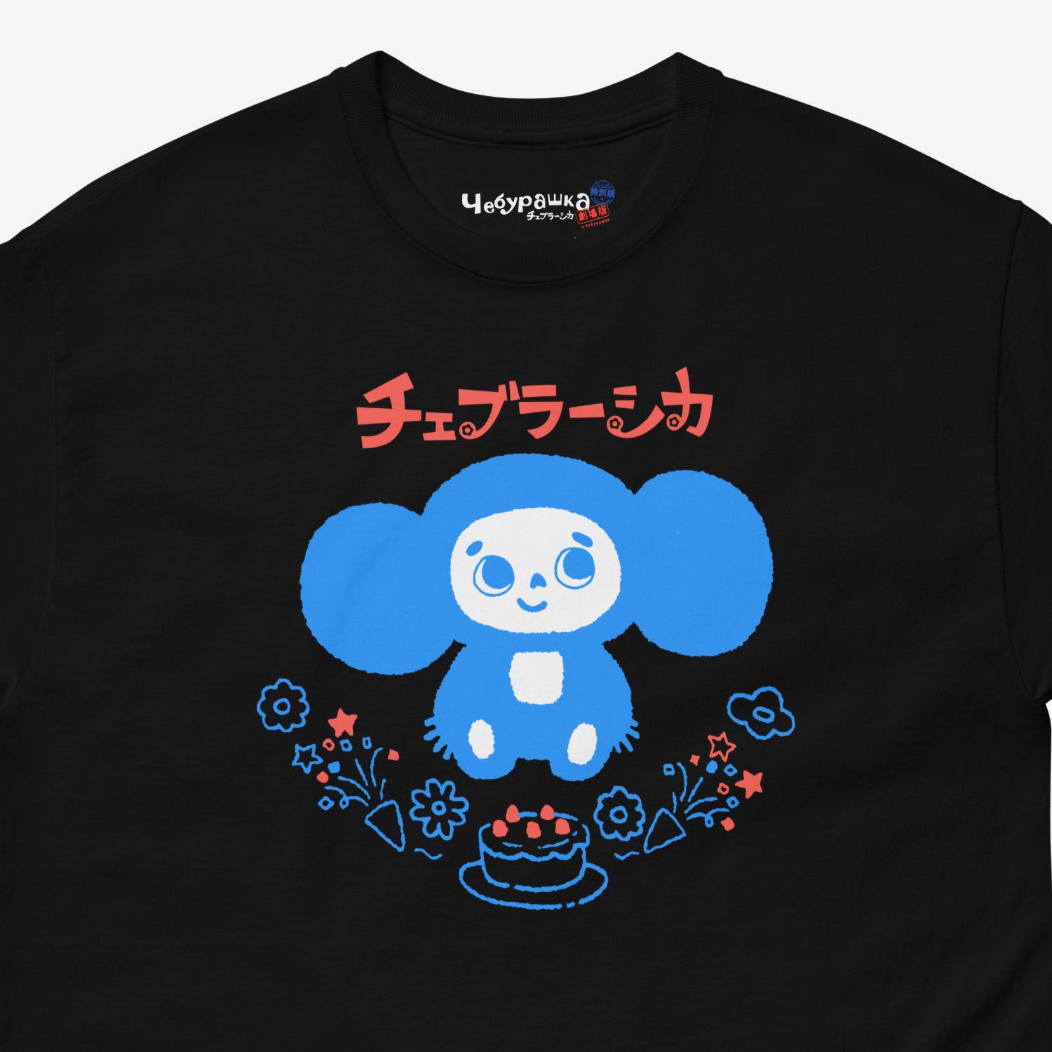 Black unisex adult tee featuring minimalist Cheburashka with a birthday cake. Japanese edition with text チェブラーシカ. Cute baby-blue print color. Closeup photo with branded necktag logo Чебурашка. www.cheburashkashop.com
