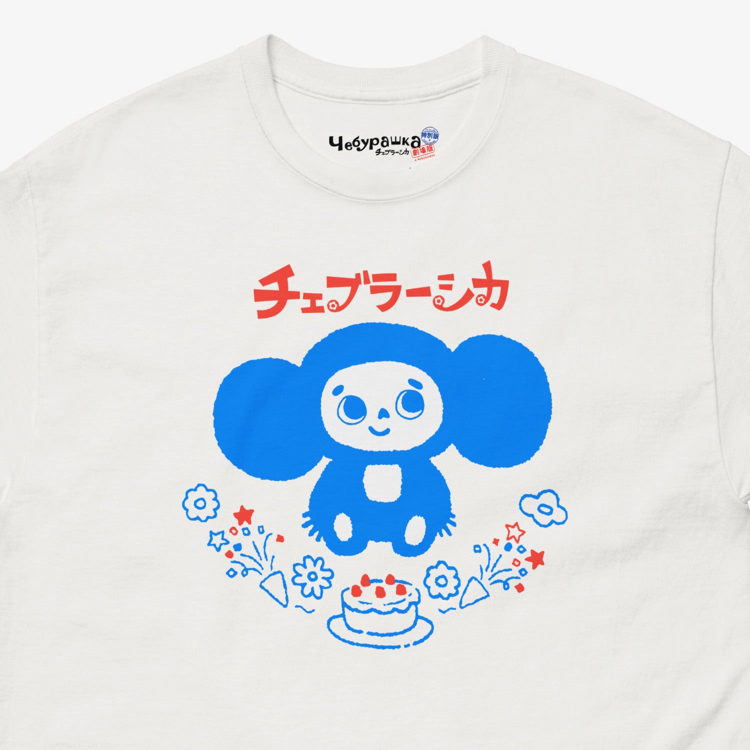 White unisex adult tee featuring minimalist Cheburashka with a birthday cake. Japanese edition with text チェブラーシカ. Cute baby-blue print color. Closeup photo with branded necktag logo Чебурашка. www.cheburashkashop.com