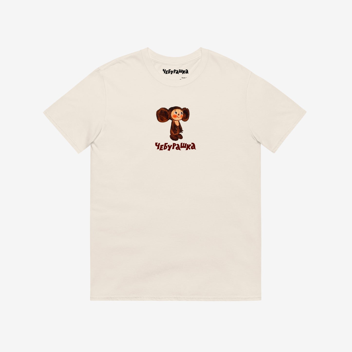 Unisex natural-white Tee featuring original Soviet cartoon character clumsy painted Cheburashka and Чебурашка logo in brown. High-quality 100% cotton. 