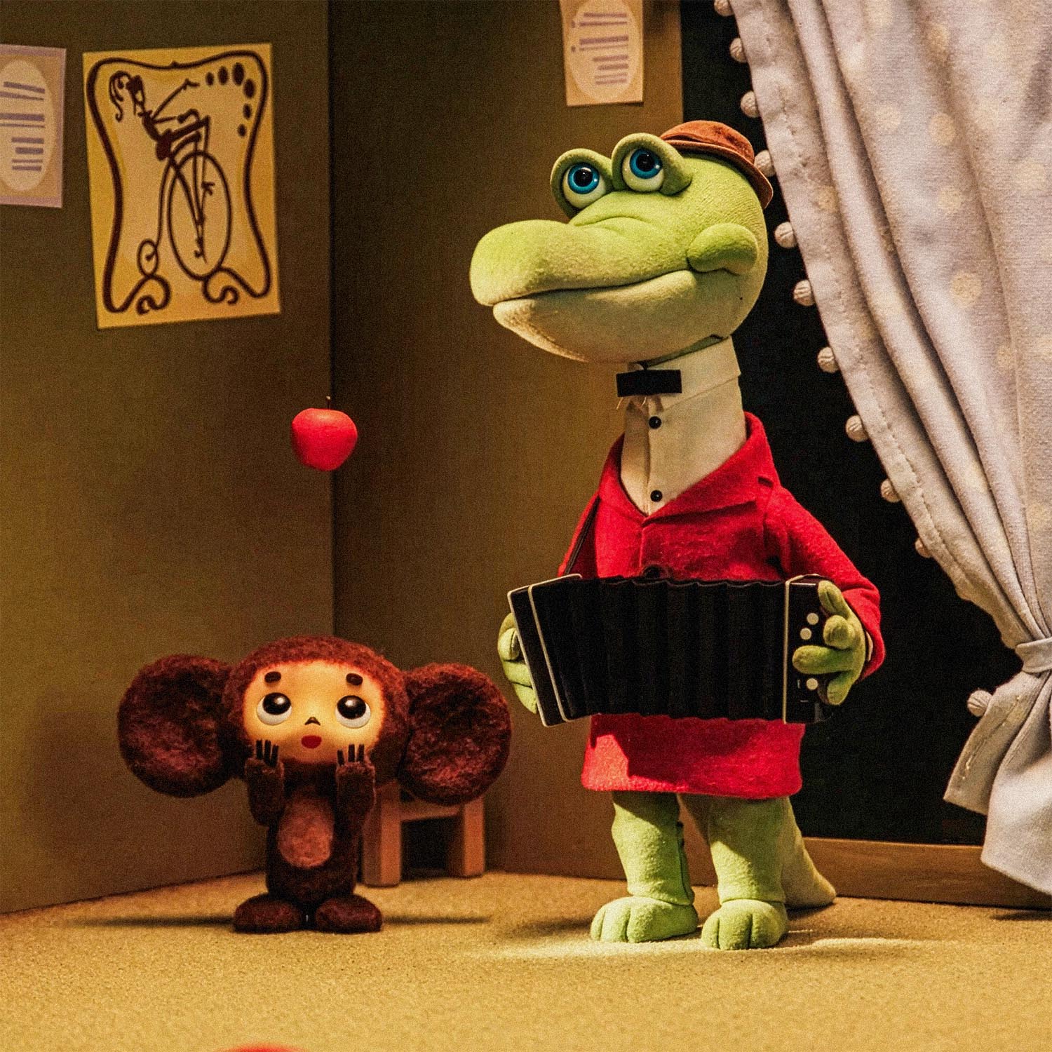 Closeup of a print featuring a scene from the Soviet cartoon Cheburashka, showing Cheburashka playing with apples and his friend Gena the crocodile playing accordion in a room.