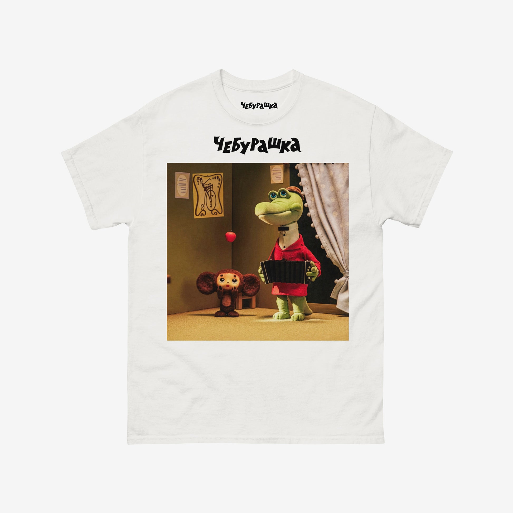 White unisex T-shirt featuring a scene from the Soviet cartoon Cheburashka, showing Cheburashka playing with apples and his friend Gena the crocodile playing accordion in a room. With Чебурашка logo above the image.