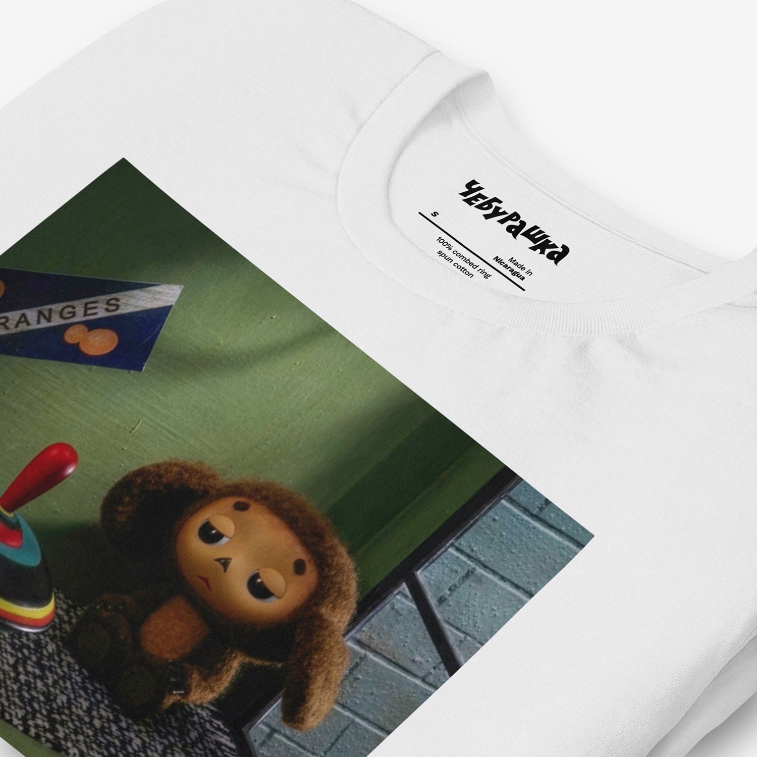 Unisex T-shirt with large print of original Soviet cartoon character Cheburashka sitting sad in phone booth and logo Чебурашка. 2013 edition. Closeup print details..