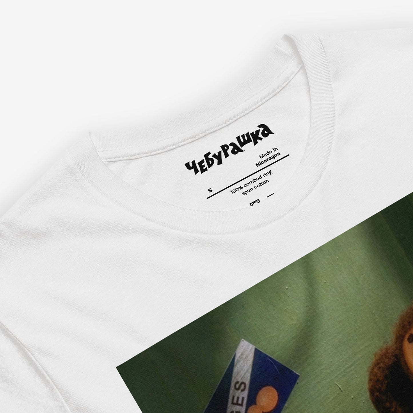 Unisex T-shirt with large print of original Soviet cartoon character Cheburashka sitting sad in phone booth and logo Чебурашка. 2013 edition. Front closeup.