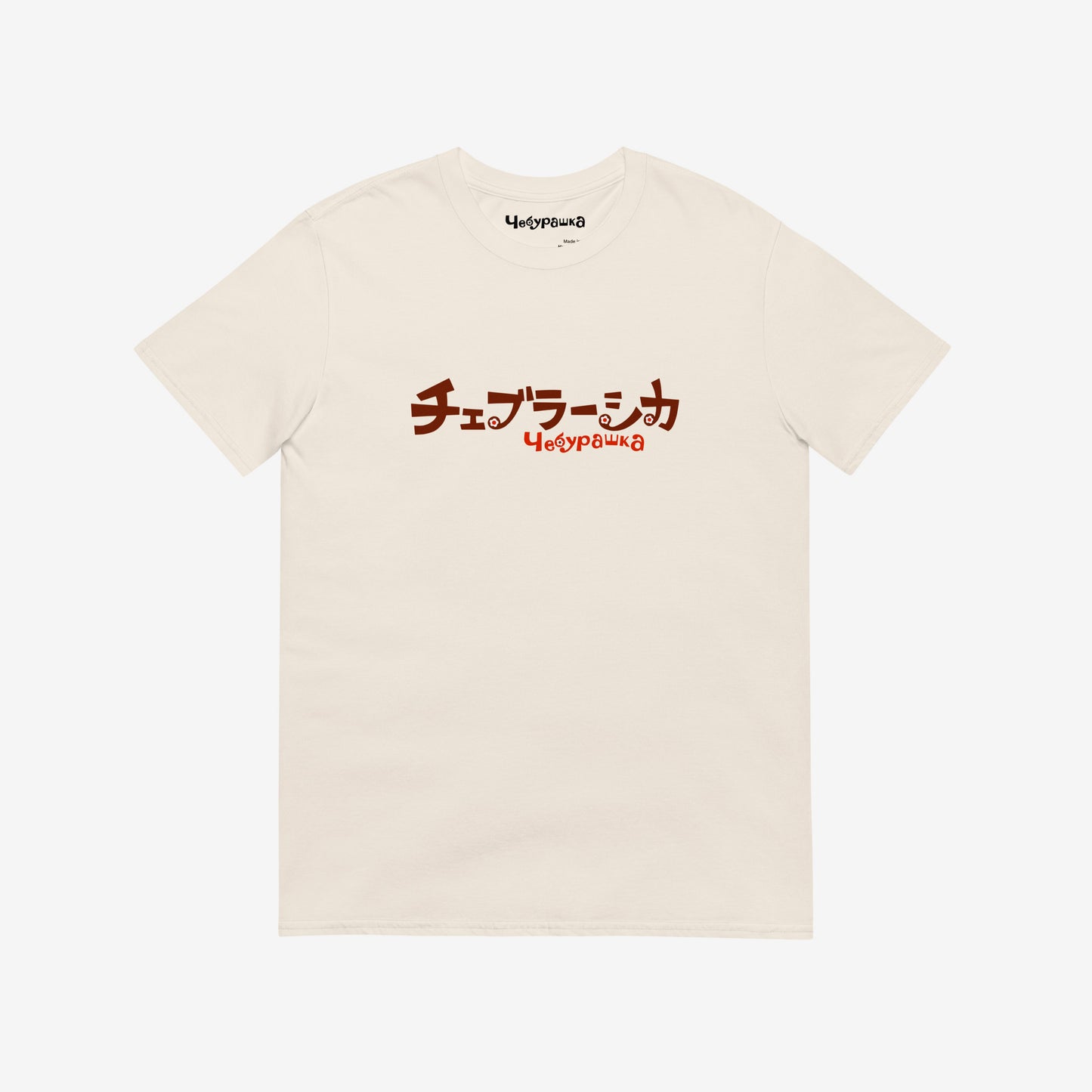 A beige short-sleeve unisex Cheburashka, original Soviet cartoon Tee with a brown チェブラーシカ logo in japanese and a smaller 'Чебурашка' logo in russian underneath.