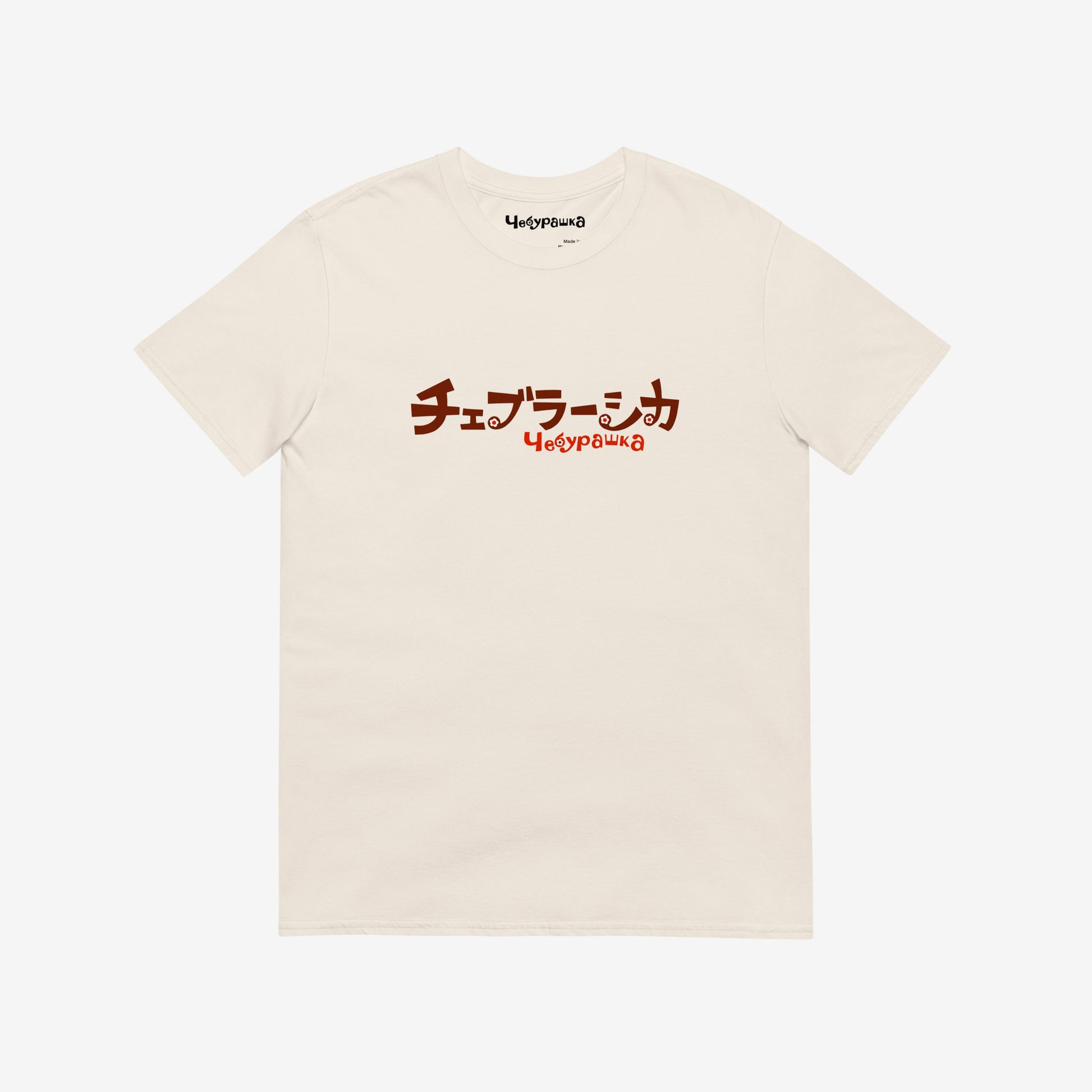 A beige short-sleeve unisex Cheburashka, original Soviet cartoon Tee with a brown チェブラーシカ logo in japanese and a smaller 'Чебурашка' logo in russian underneath.