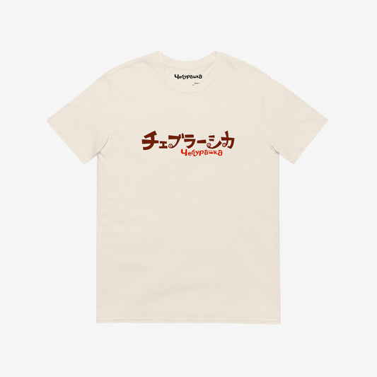 A beige short-sleeve unisex Cheburashka, original Soviet cartoon Tee with a brown チェブラーシカ logo in japanese and a smaller 'Чебурашка' logo in russian underneath.