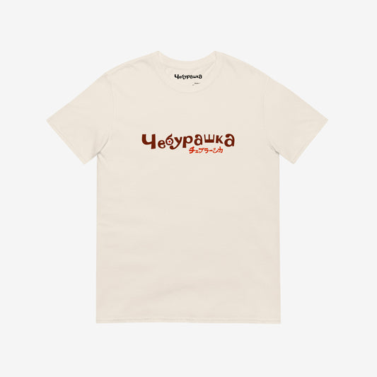 A beige short-sleeve unisex Cheburashka, original Soviet cartoon Tee with a brown 'Чебурашка' logo in russian and smaller underneath logo in japanese チェブラーシカ.