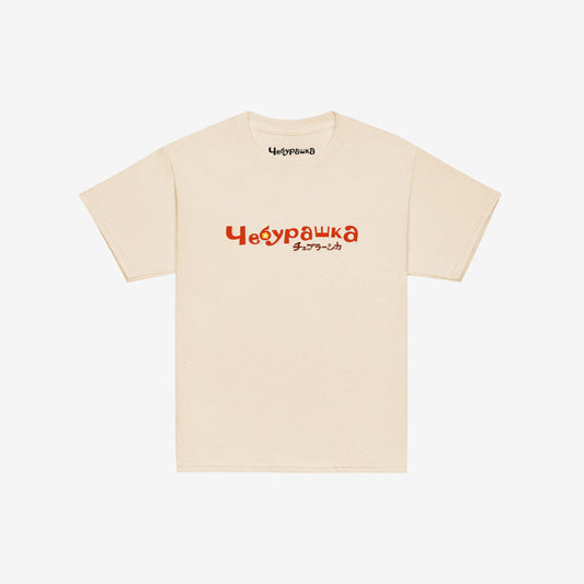 A beige short-sleeve unisex Cheburashka, original Soviet cartoon youth Tee with a light brown 'Чебурашка' logo in russian and smaller underneath logo in japanese チェブラーシカ.