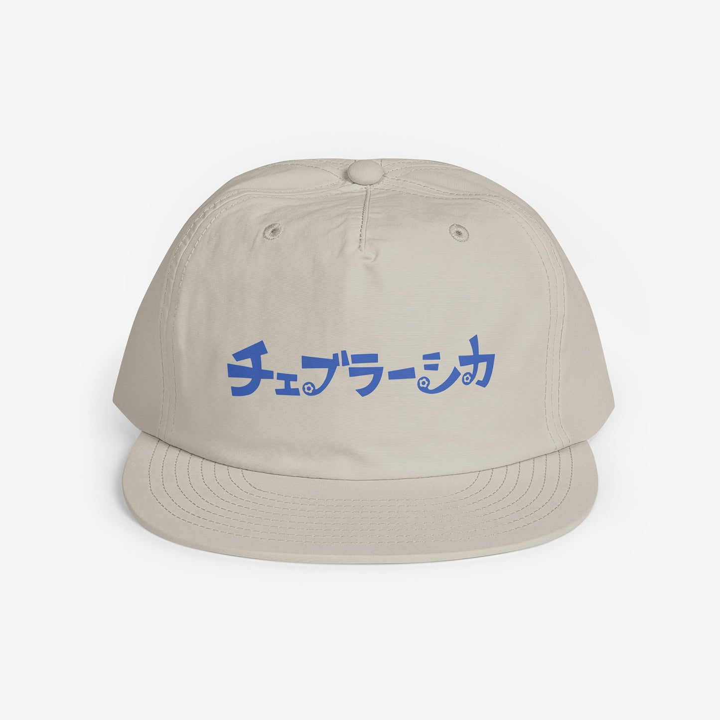 A light beige surf cap with a flat brim, featuring Cheburashka Soviet cartoon logo in japanese チェブラーシカ on the front. Front side.