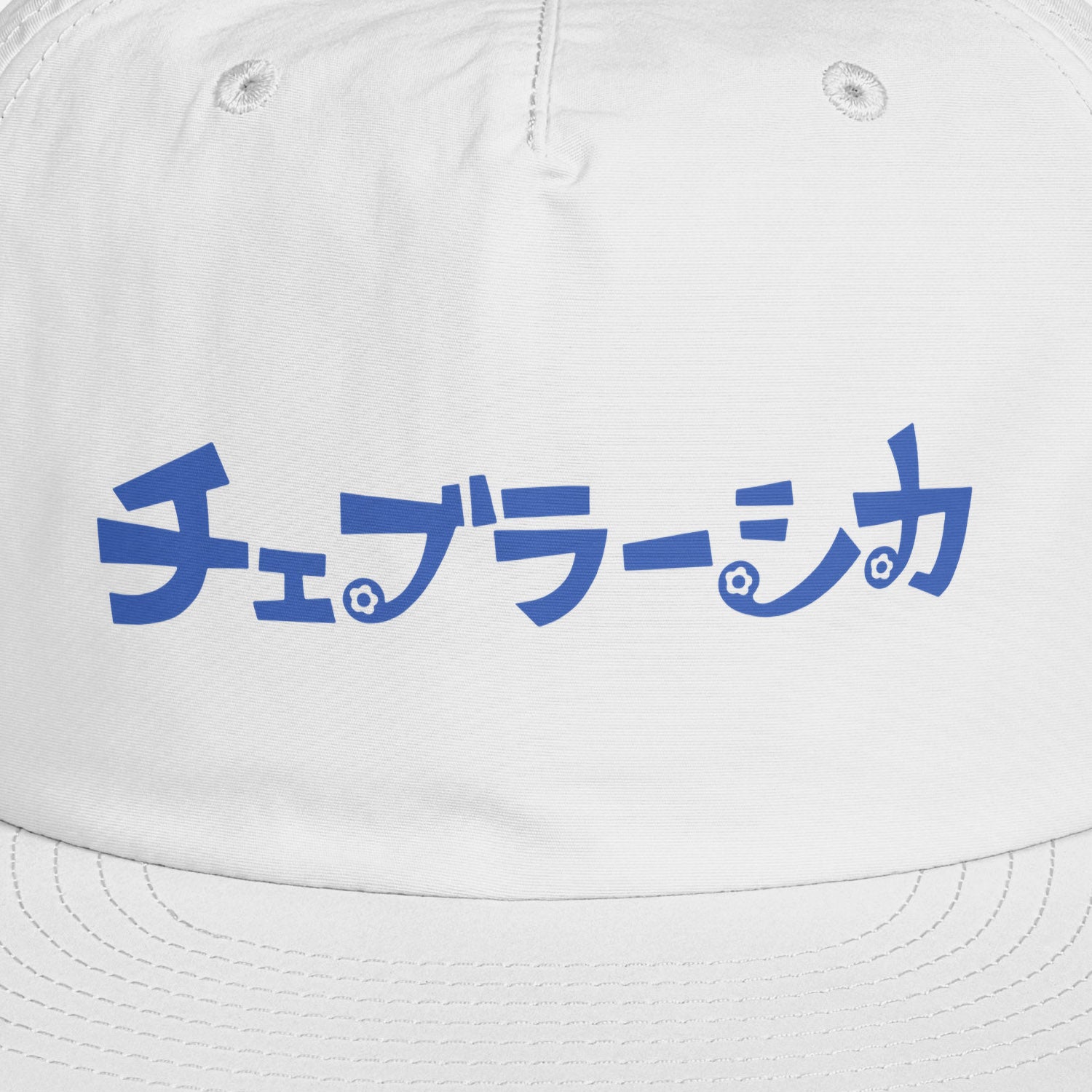A white surf cap with a flat brim, featuring Cheburashka Soviet cartoon logo in japanese チェブラーシカ on the front. Front closeup.