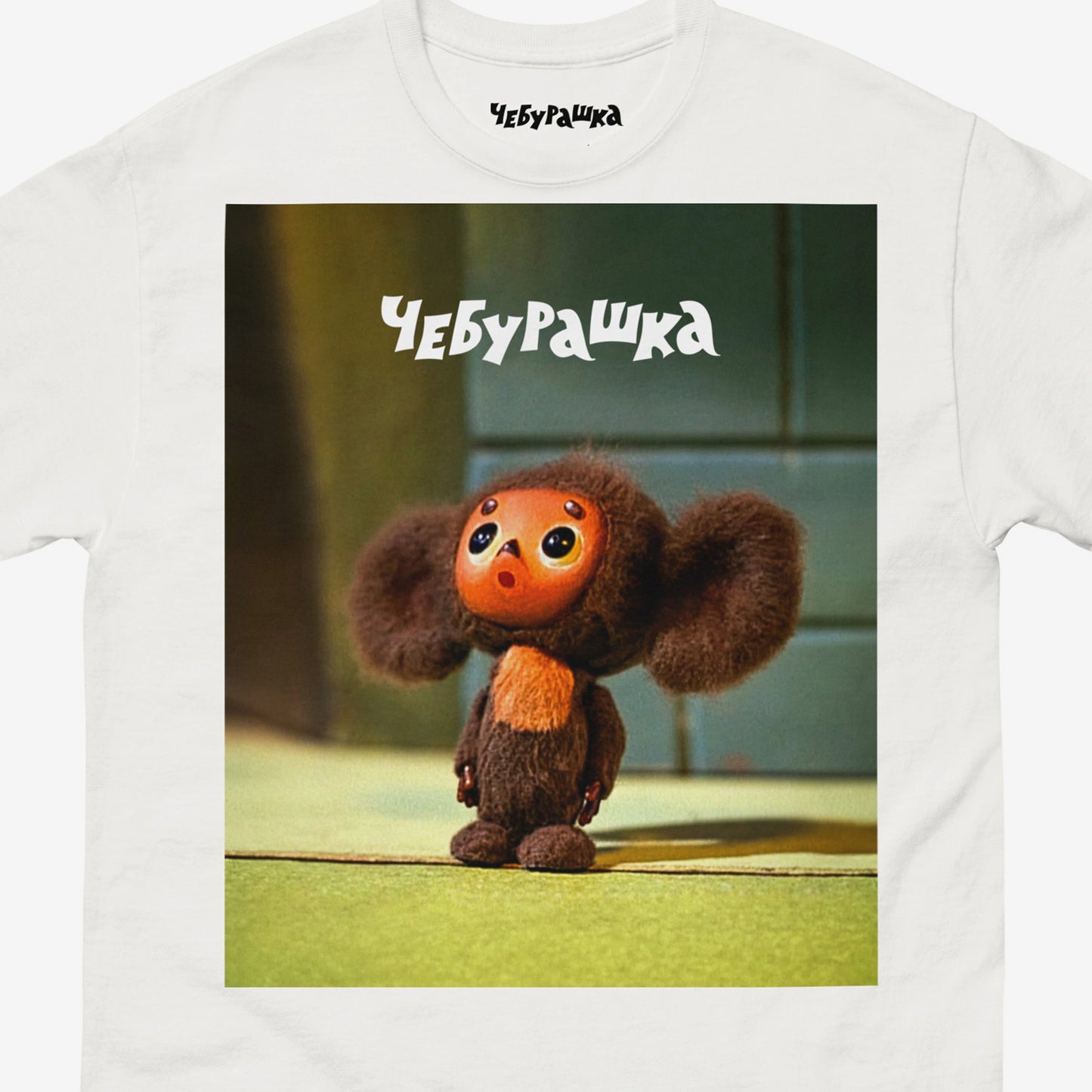 White unisex T-shirt with large print of original surprised Cheburashka from Soviet cartoon. Old version. With logo Чебурашка. Closeup photo.