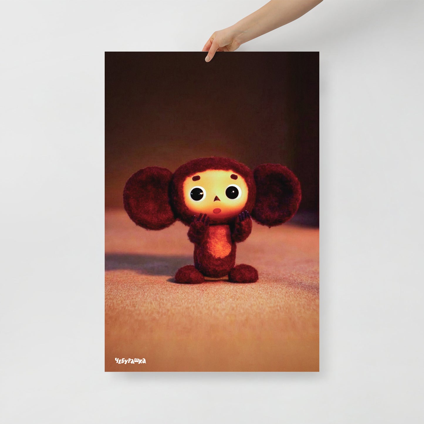 Hand holding large 61x91cm poster with original Surprised Cheburashka from Soviet cartoon. With logo Чебурашка.