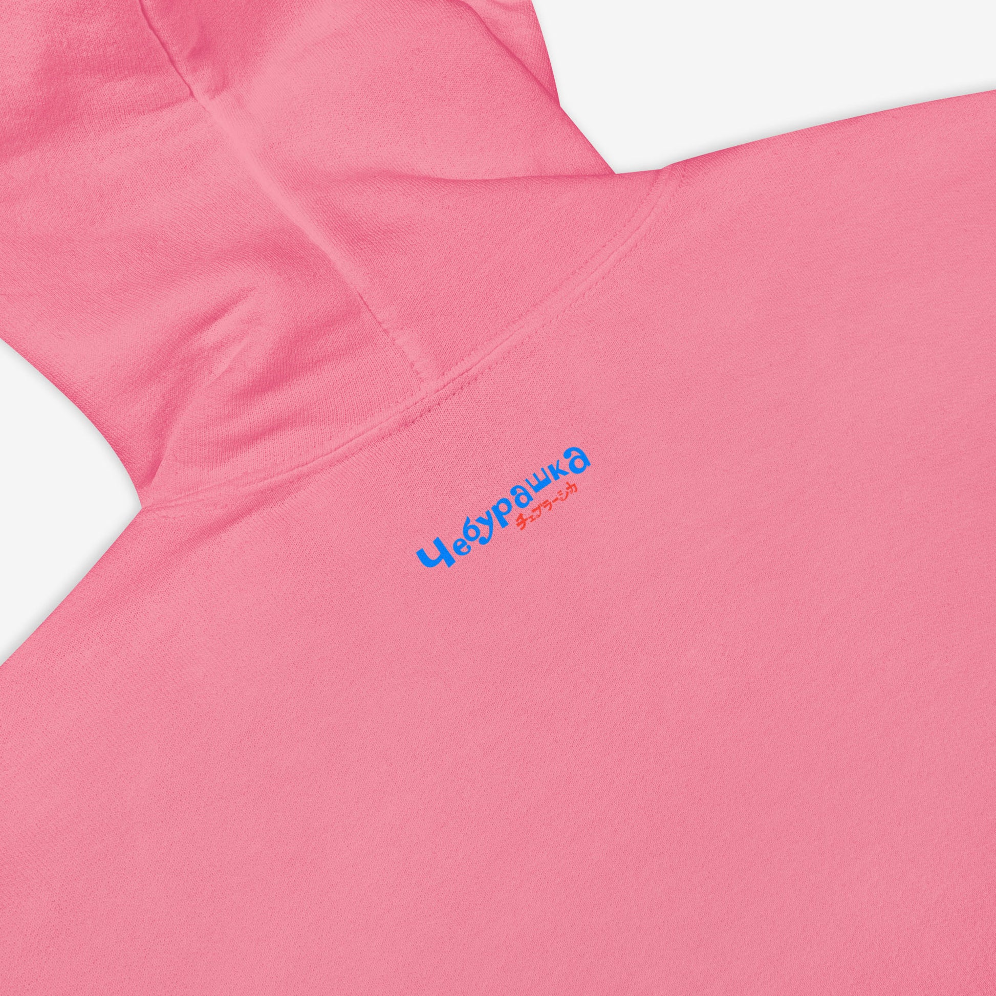 Pink unisex hoodie with minimalist graphic of Cheburashka eating Eskimo ice-cream and チェブラーシカ japanese logo in red. Back side closeup print details featuring Чебурашка logo.