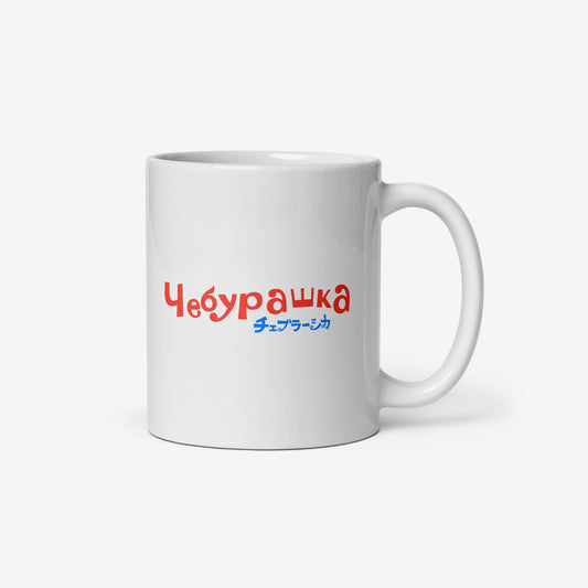 White coffee cup with Cheburashka sitting on a box of oranges and チェブラーシカ logo in red. Back.