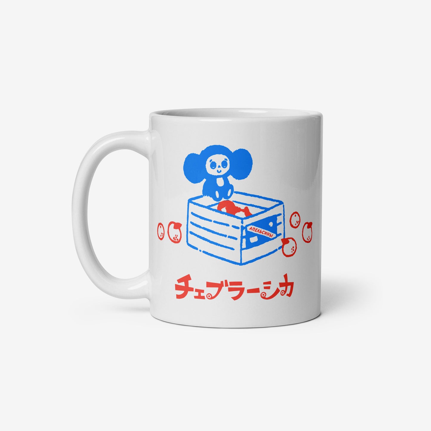 White coffee cup with Cheburashka sitting on a box of oranges and チェブラーシカ logo in red. Front.