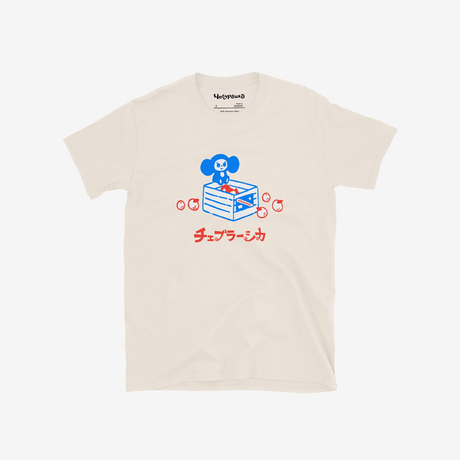 Beige unisex T-shirt with original Soviet cartoon character Cheburashka sitting on a box of oranges and チェブラーシカ logo in red. Front.