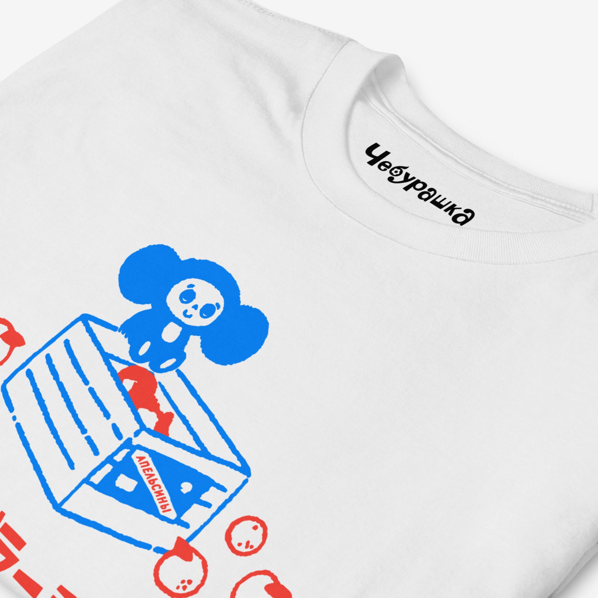 White unisex T-shirt with original Soviet cartoon character Cheburashka sitting on a box of oranges and チェブラーシカ logo in red. Front closeup.