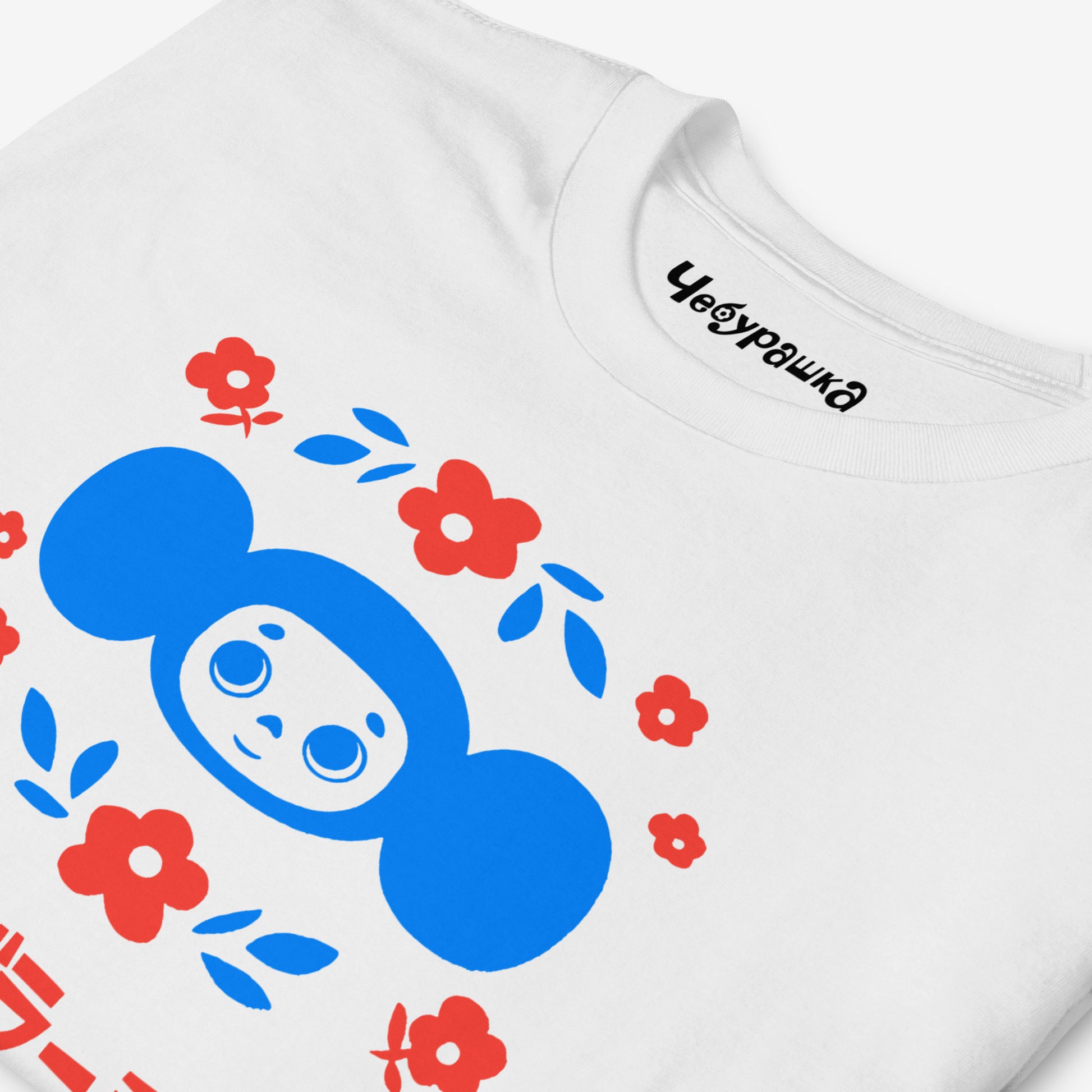 White unisex T-shirt with original Soviet cartoon character Cheburashka among a pattern of flowers and with logo in japanese チェブラーシカ. Closeup print details.