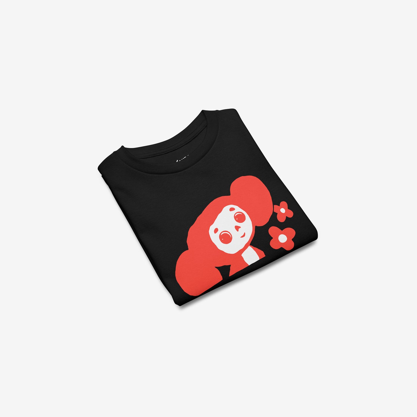 Black unisex youth T-shirt with minimalist graphic of Cheburashka with flowers and チェブラーシカ japanese logo in red. Folded.