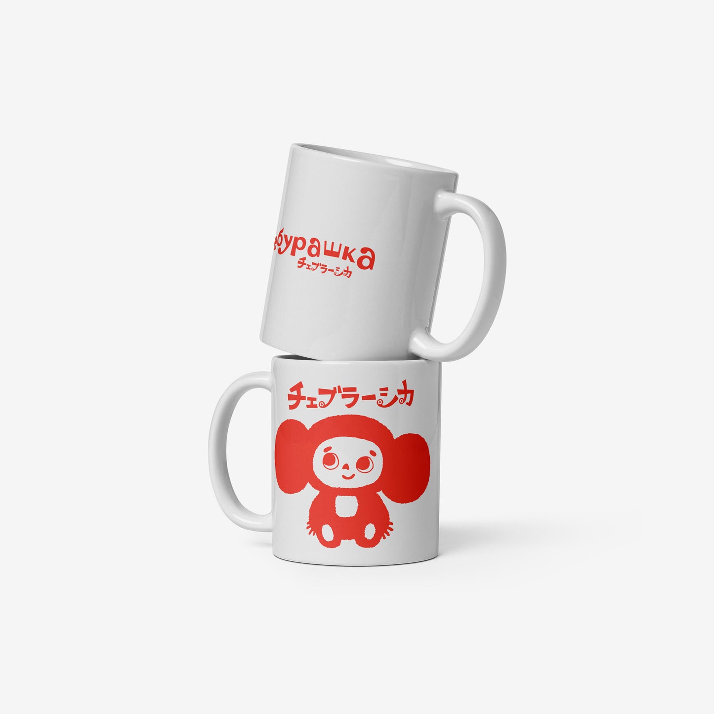 White coffee cup with minimalist graphic of smiley Cheburashka and チェブラーシカ logo in red. Front and back side with Чебурашка logo.