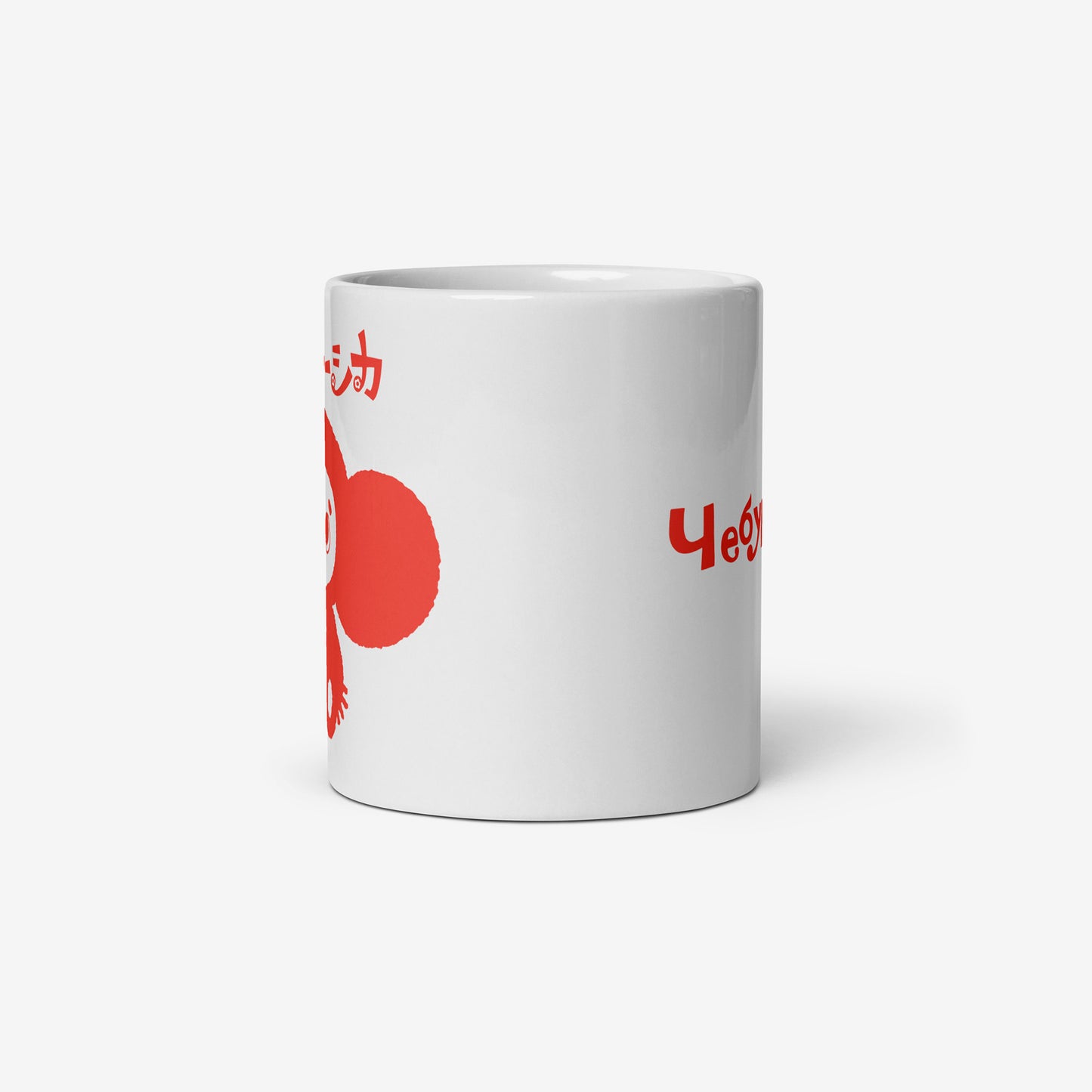 White coffee cup with minimalist graphic of smiley Cheburashka and チェブラーシカ logo in red. Side photo with partially seen print on the front and on the back.