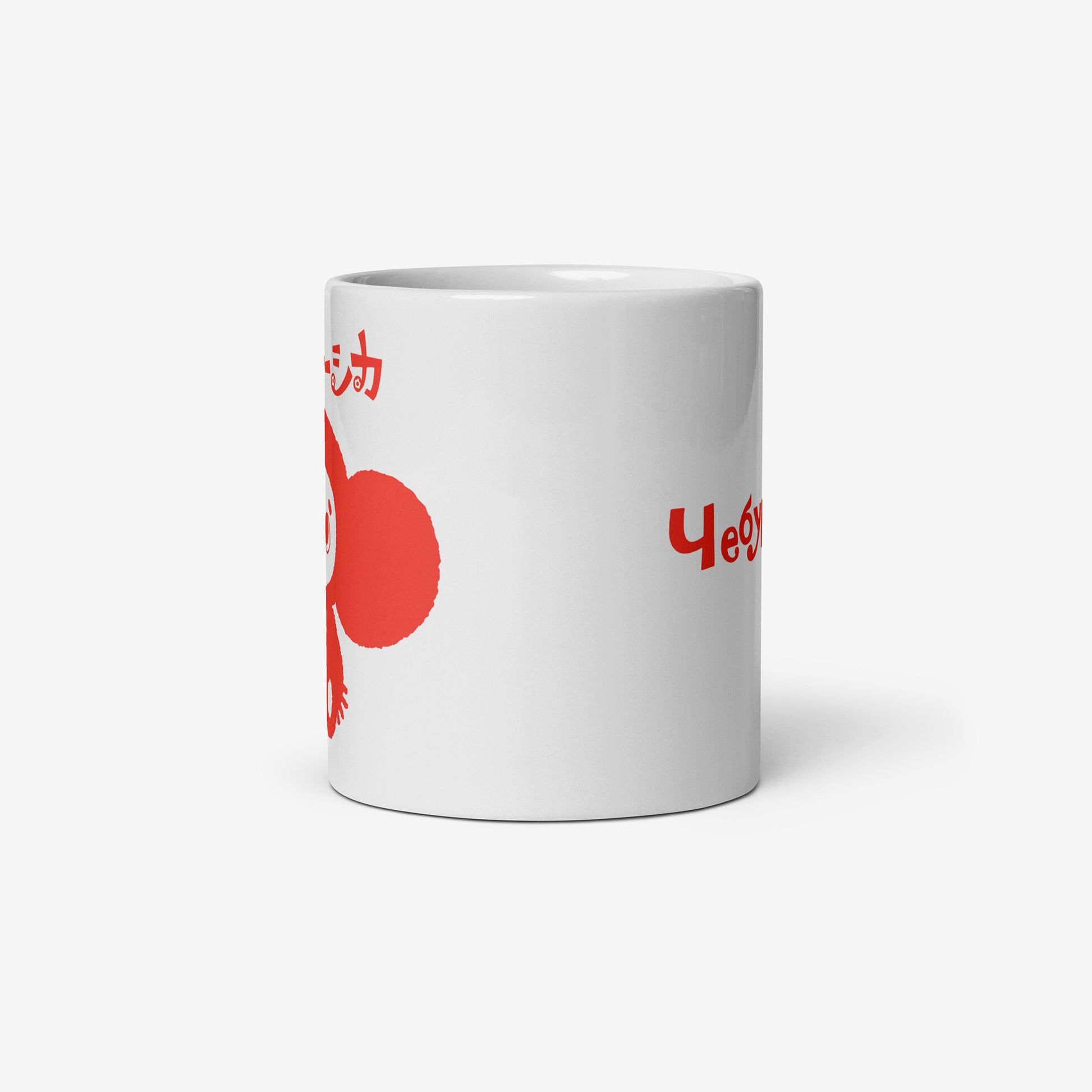 White coffee cup with minimalist graphic of smiley Cheburashka and チェブラーシカ logo in red. Side photo with partially seen print on the front and on the back.